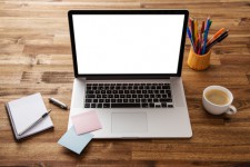 Notebook aufgeklappt auf Holztisch